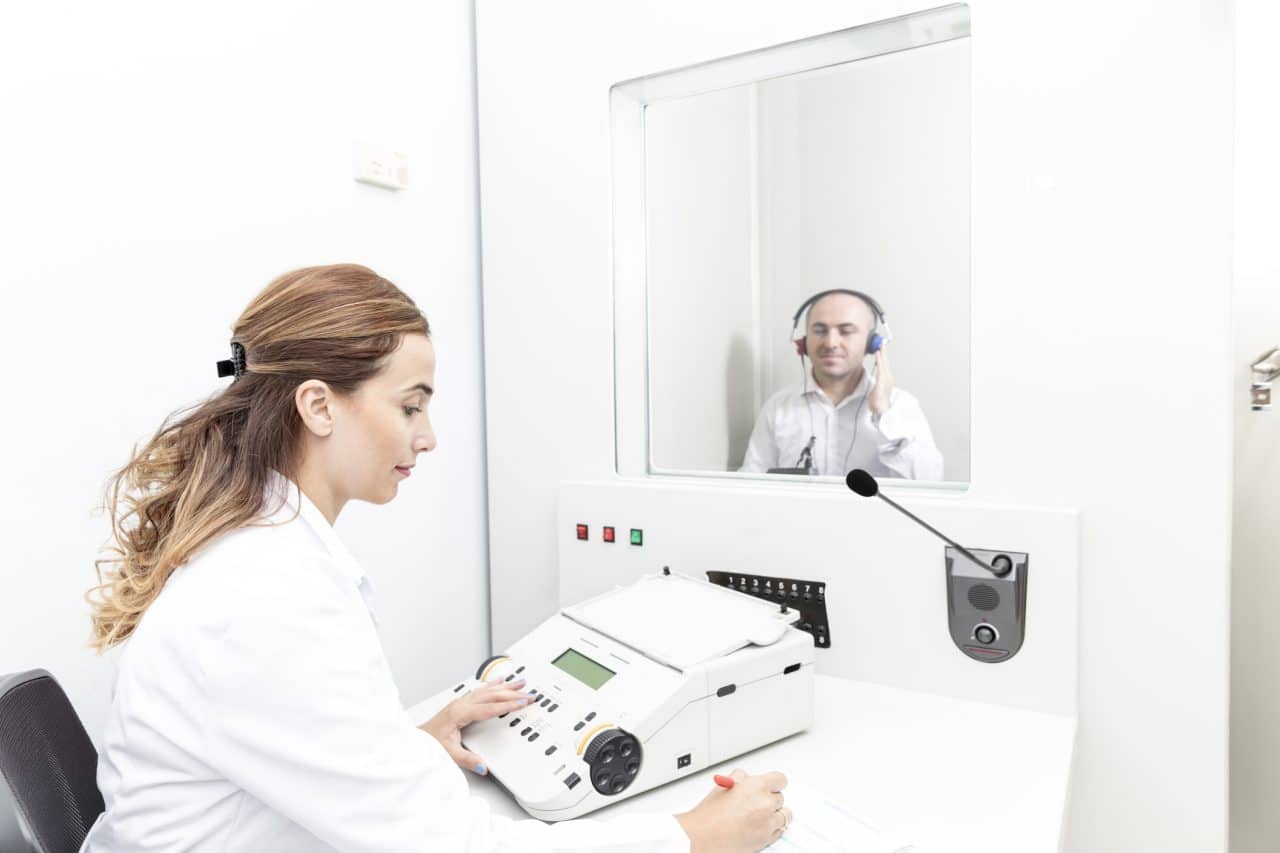 Patient receiving a hearing test in a booth