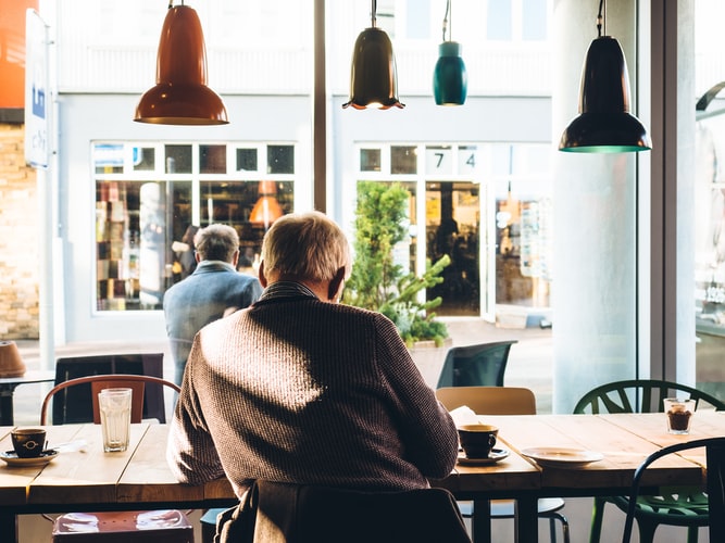 Man sitting inside of a coffee shop.