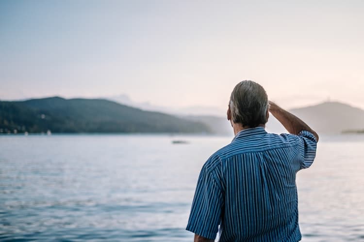 Man looks out at a lake.