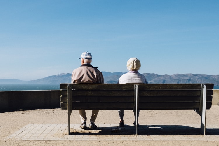 A couple sitting at a bench.