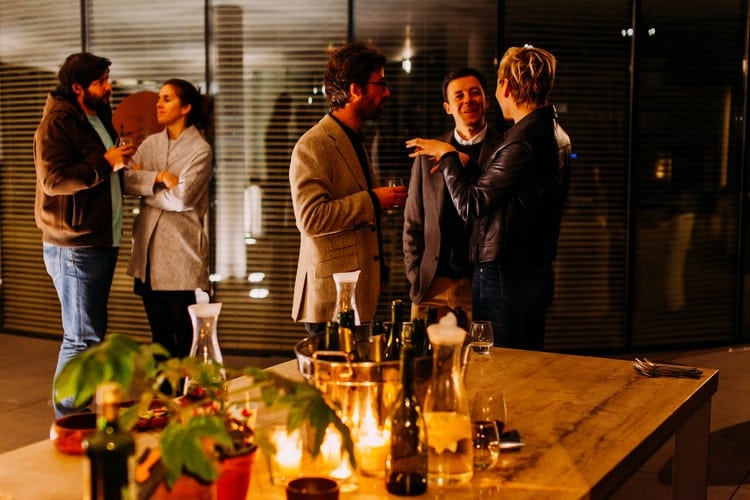 Group of people chatting together at a noisy dinner party.