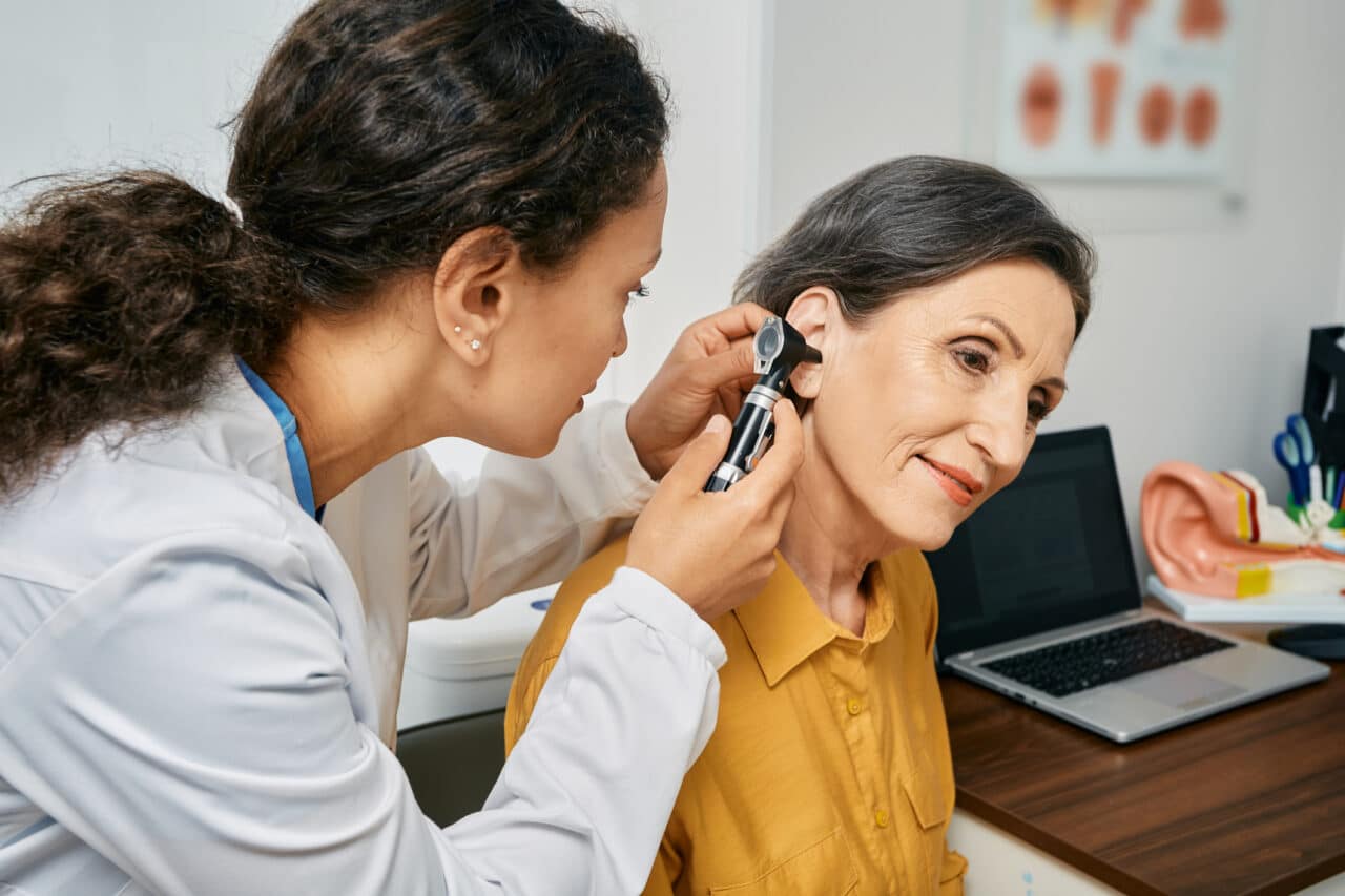 Woman getting her ears examined by a medical professional.