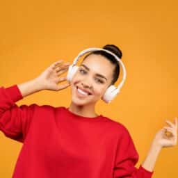 Woman in a red sweater wearing headphones.