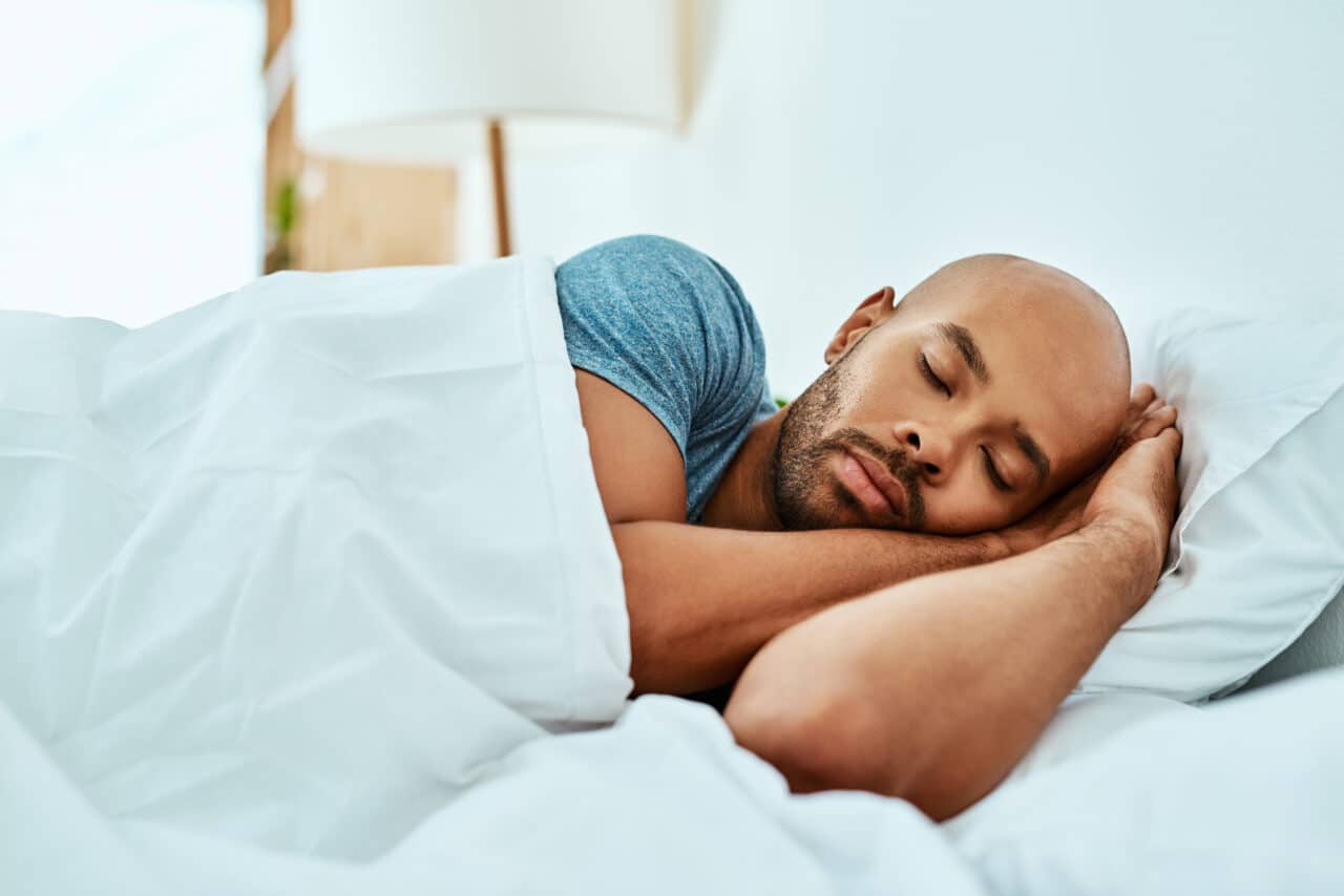 Young man sleeping peacefully in his bed.