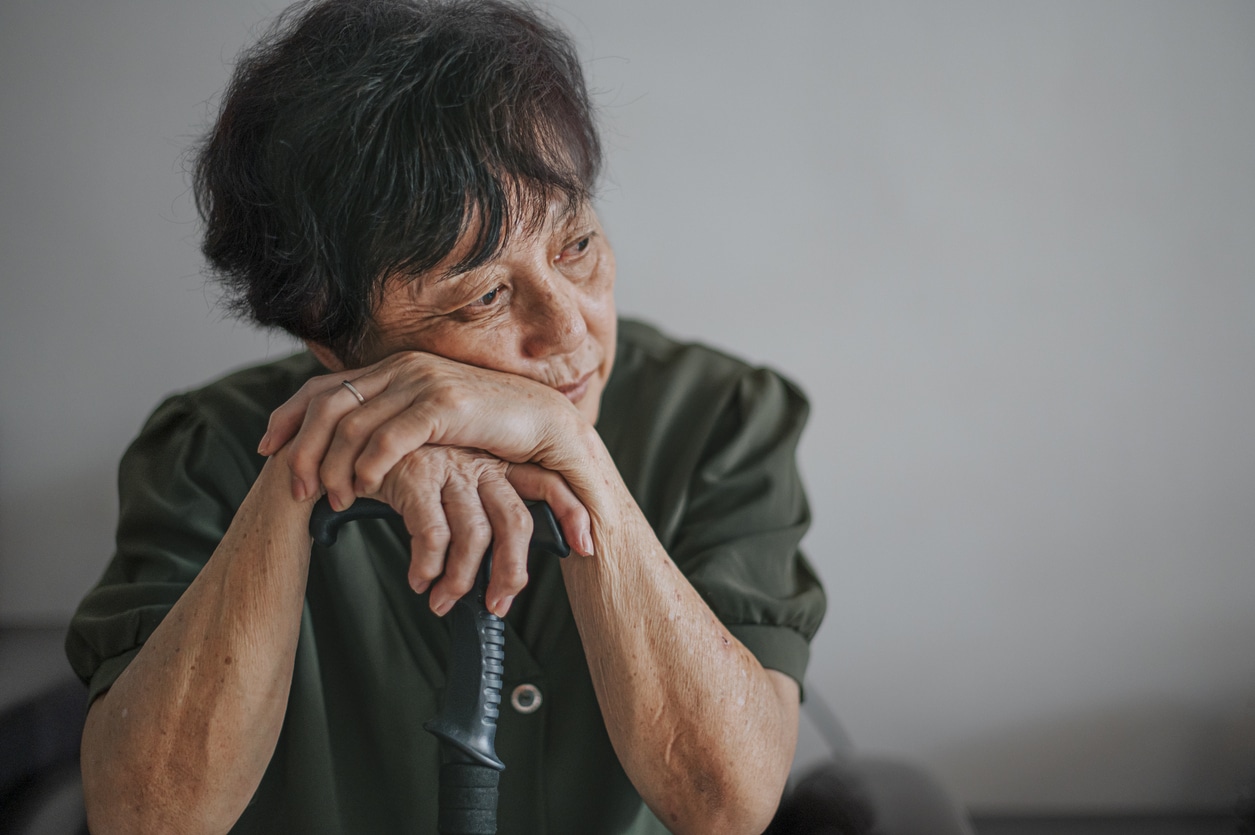 Depressed woman sitting with head in hands.