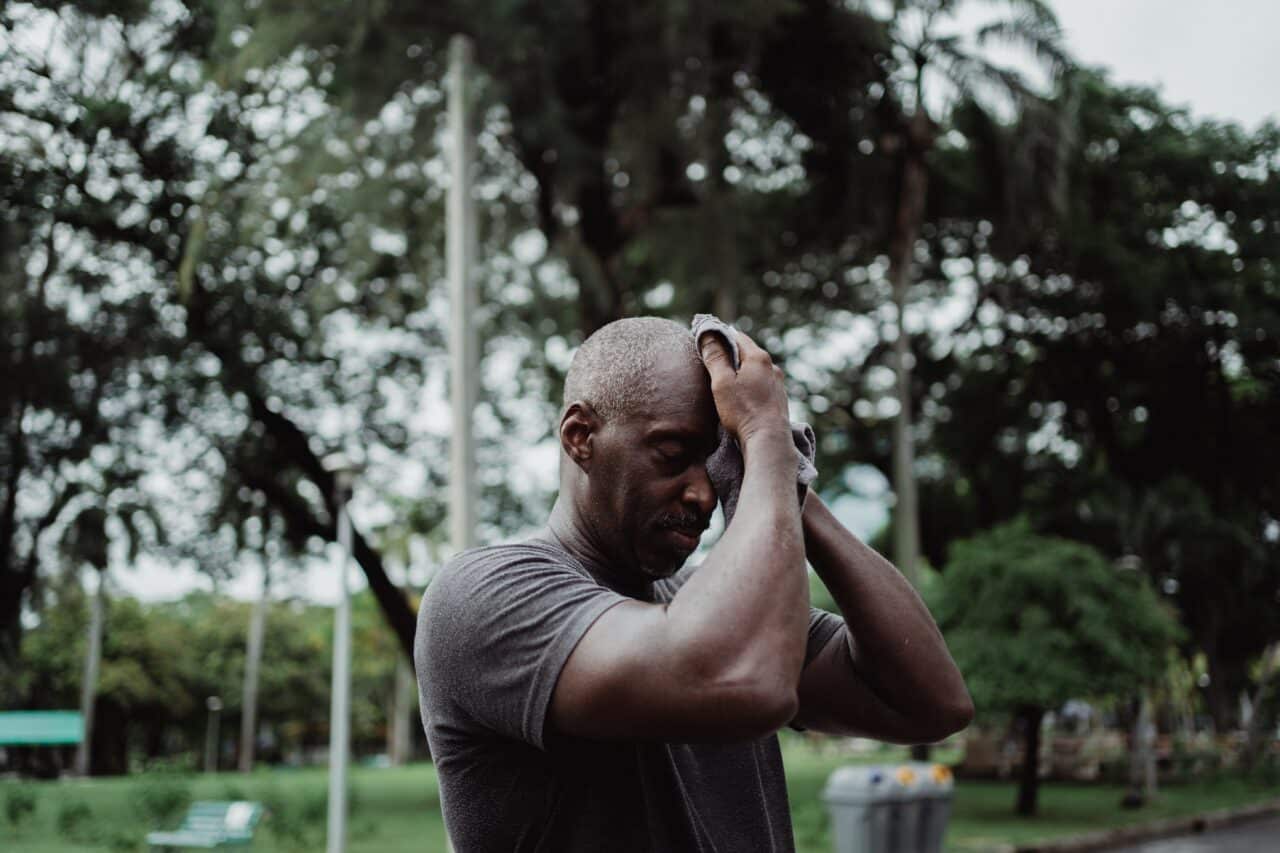 Senior man sweating after going for a walk on a hot day.