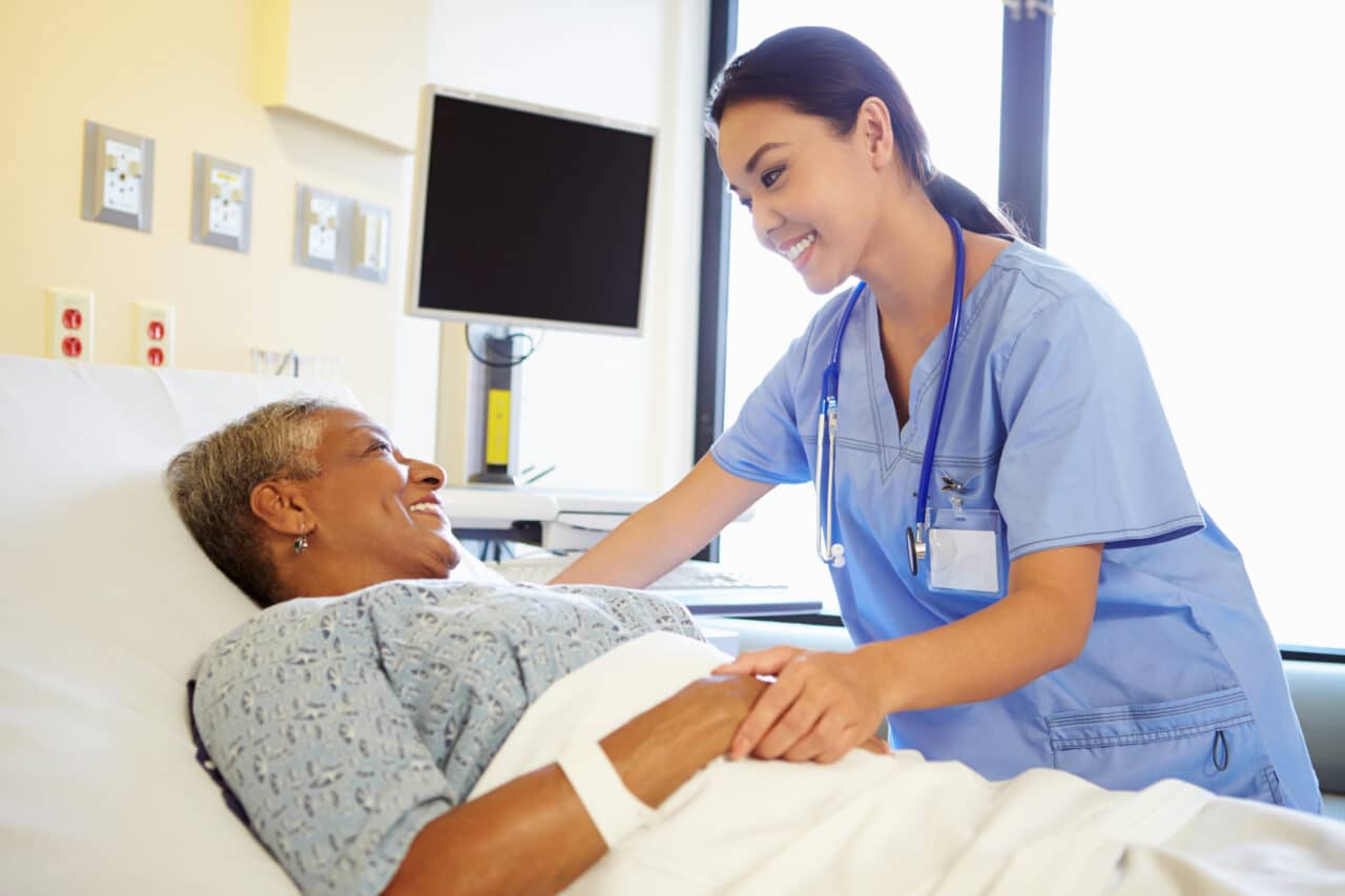Nurse talking to a senior woman patient in the hospital.