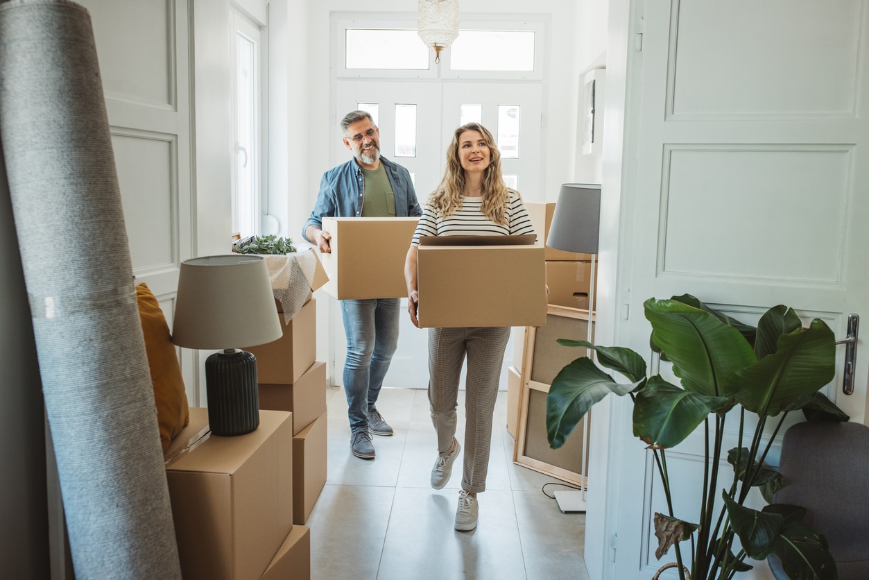 Mature couple moves in to their new home, unpacking boxes and enjoying the time together.