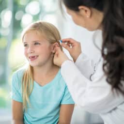 Young girl being fit for a hearing aid