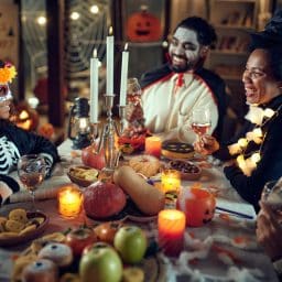 Family in costume having halloween dinner together.