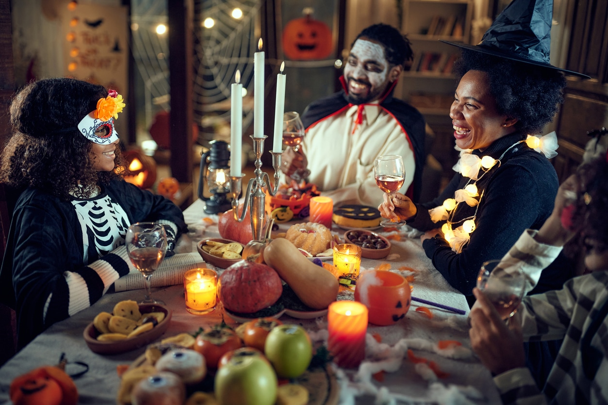 Family in costume having halloween dinner together.