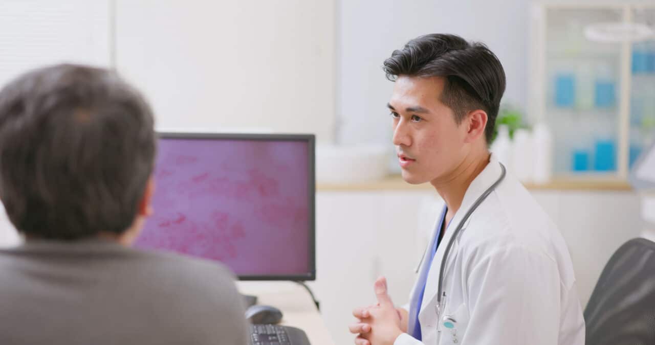 Provider explaining shingles to his patient, image of a shingles rash on his computer.