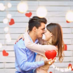 Young couple surrounded by hearts and lights