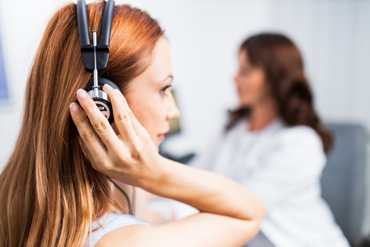 Close-up of a young woman taking a hearing test.